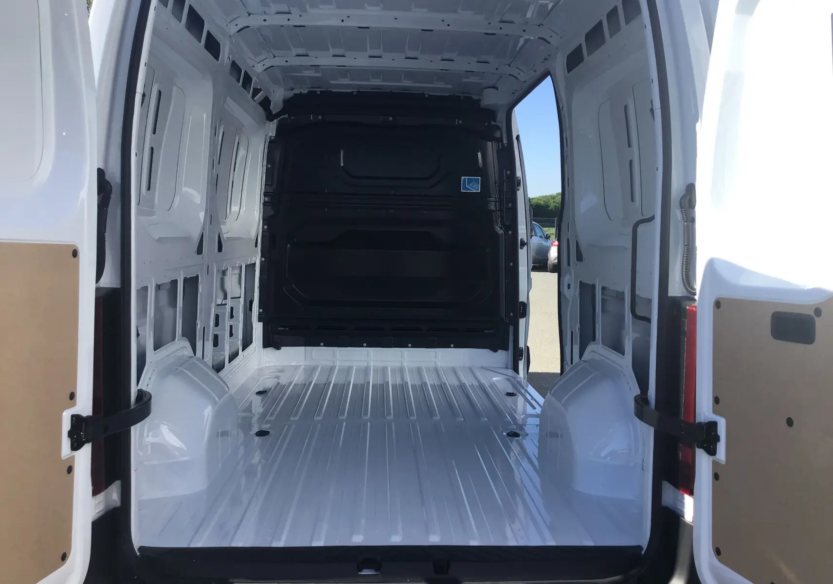 Vue intérieure arrière du Renault Master L2H2 blanc 2025, montrant l'espace de chargement vide et les portes ouvertes.