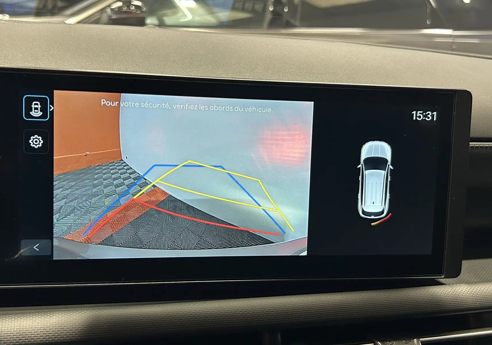 Affichage de la caméra de recul du Hyundai Tucson 2025 en Shimmering Silver, avec lignes de guidage colorées sur l'écran intérieur.