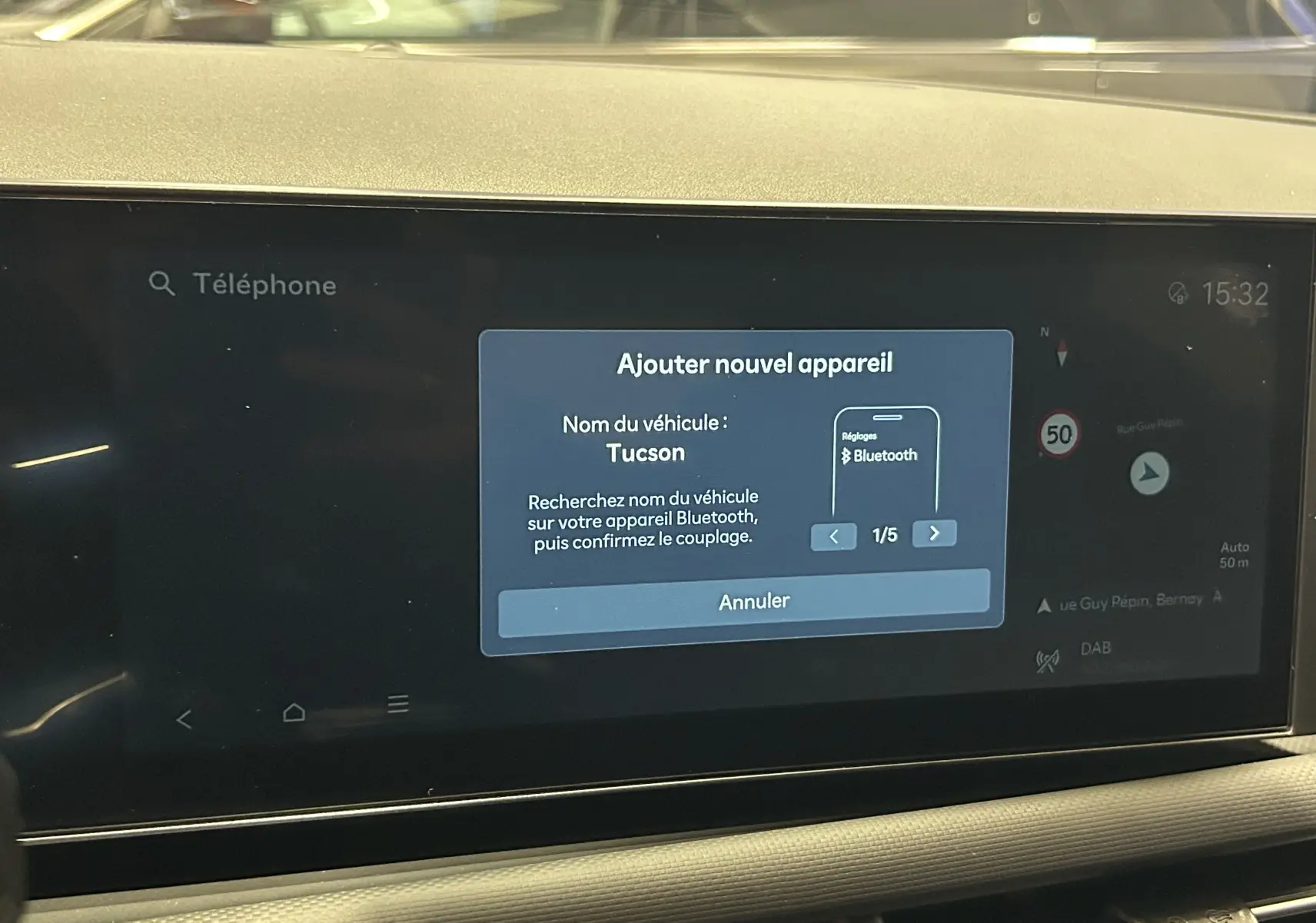Écran tactile central du Hyundai Tucson 2025 affichant l'ajout d'un appareil Bluetooth avec navigation et vitesse limitée à 50 km/h.