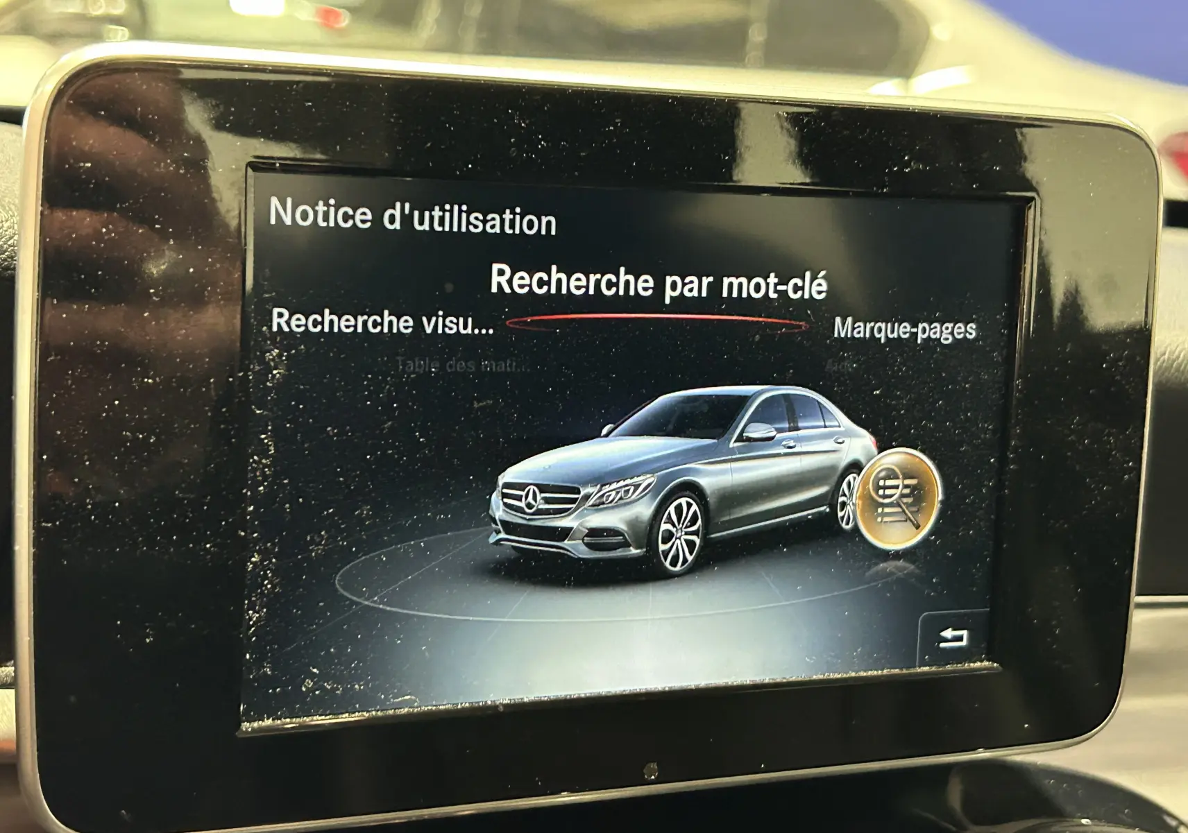 Écran multimédia affichant une illustration latérale droite d'une Mercedes Classe C bleue sur fond noir.
