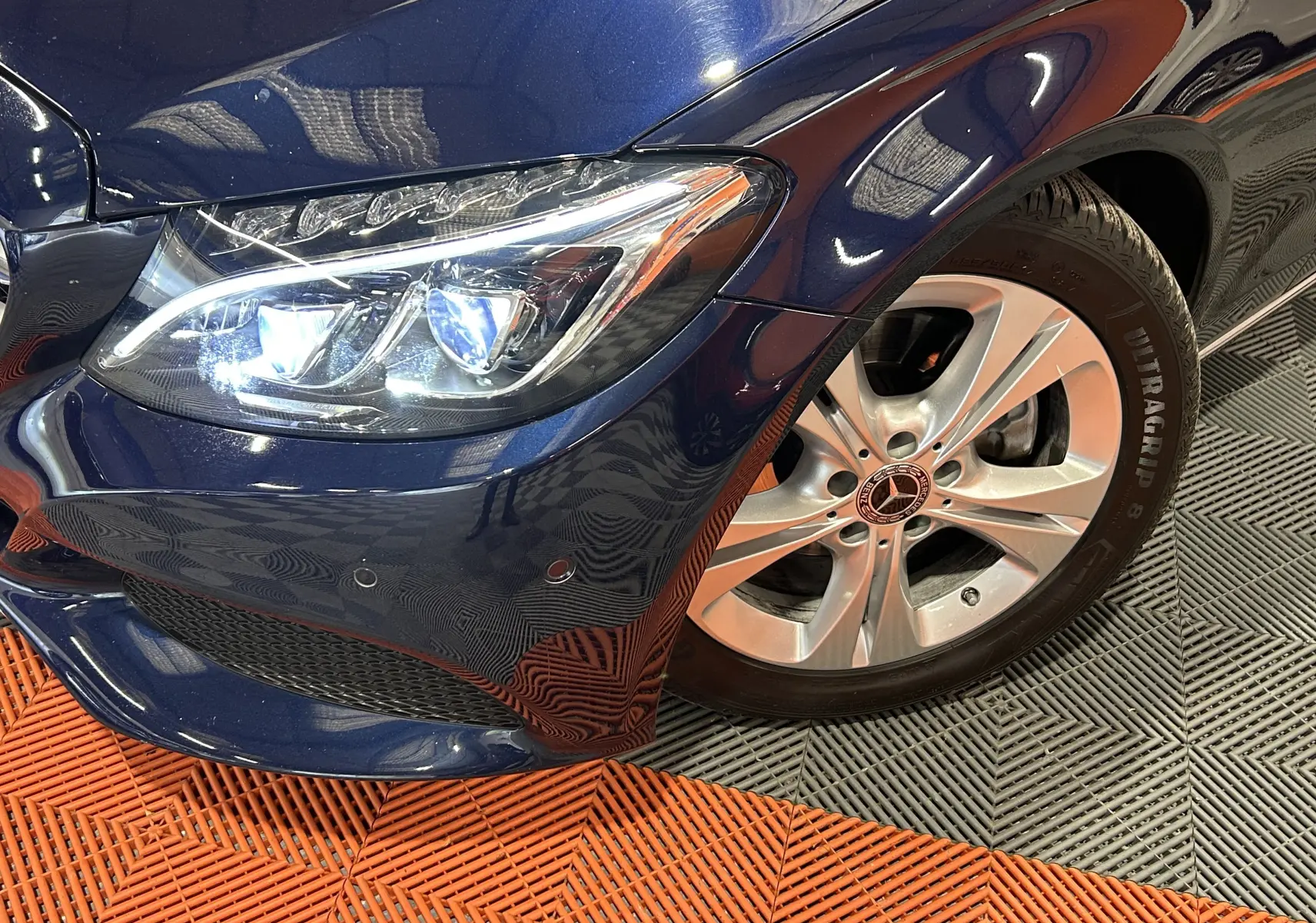 Gros plan sur l'avant droit bleu d'une Mercedes Classe C 200d, mettant en valeur le phare LED et la jante alliage.