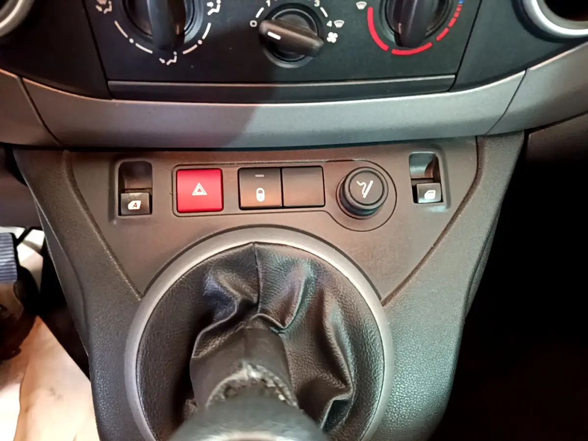 Gros plan sur la console centrale du Citroën Berlingo rouge 2016, mettant en valeur le levier de vitesses manuel et les boutons de commande.