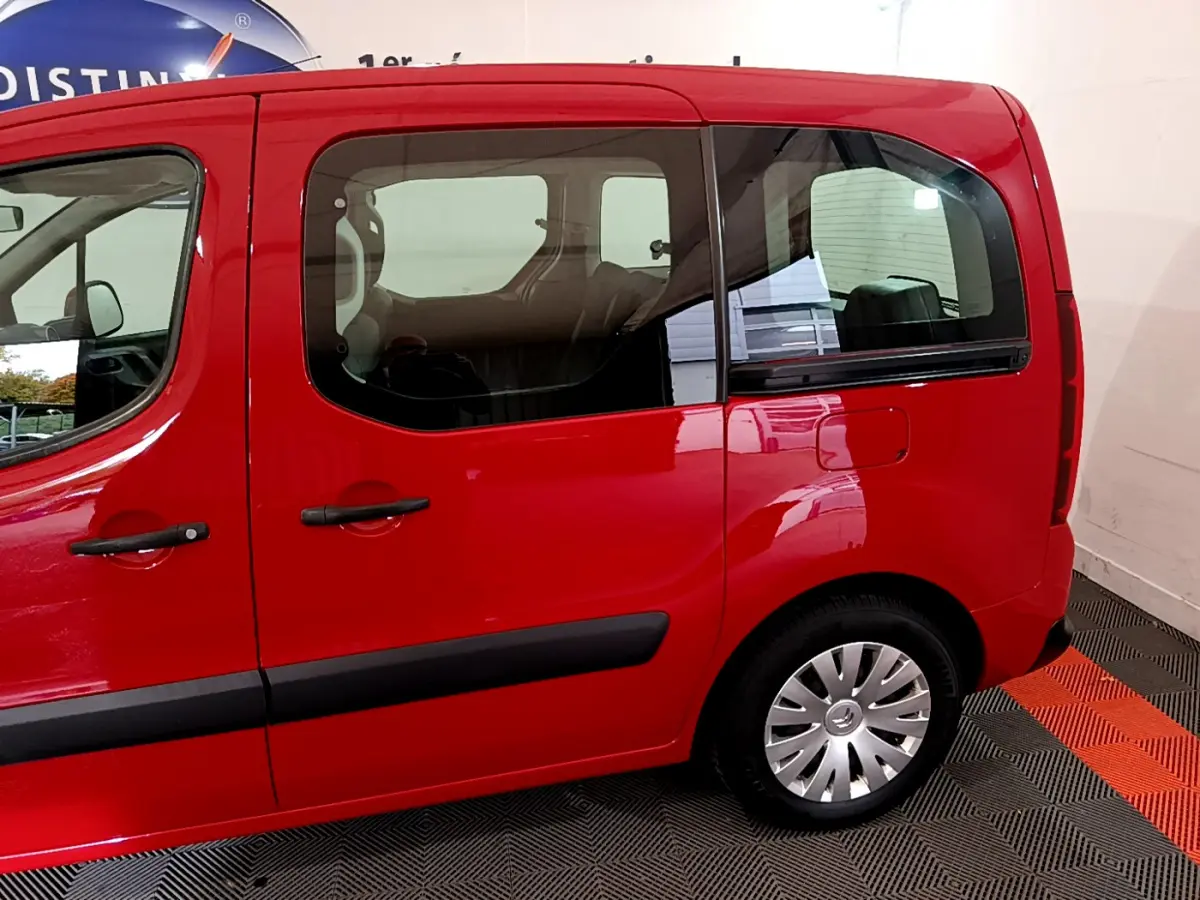 Vue latérale côté droit d'un Citroën Berlingo rouge 2016 avec portes coulissantes et jantes acier à enjoliveurs.