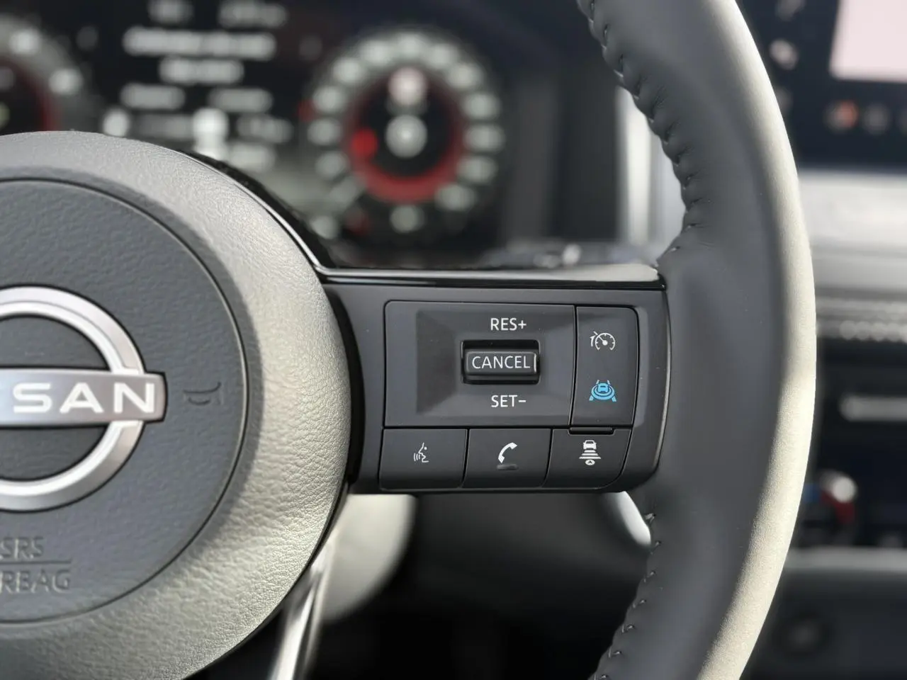 Gros plan sur le volant cuir noir du Nissan Qashqai 2025, avec commandes de régulateur de vitesse et assistance au maintien de voie.