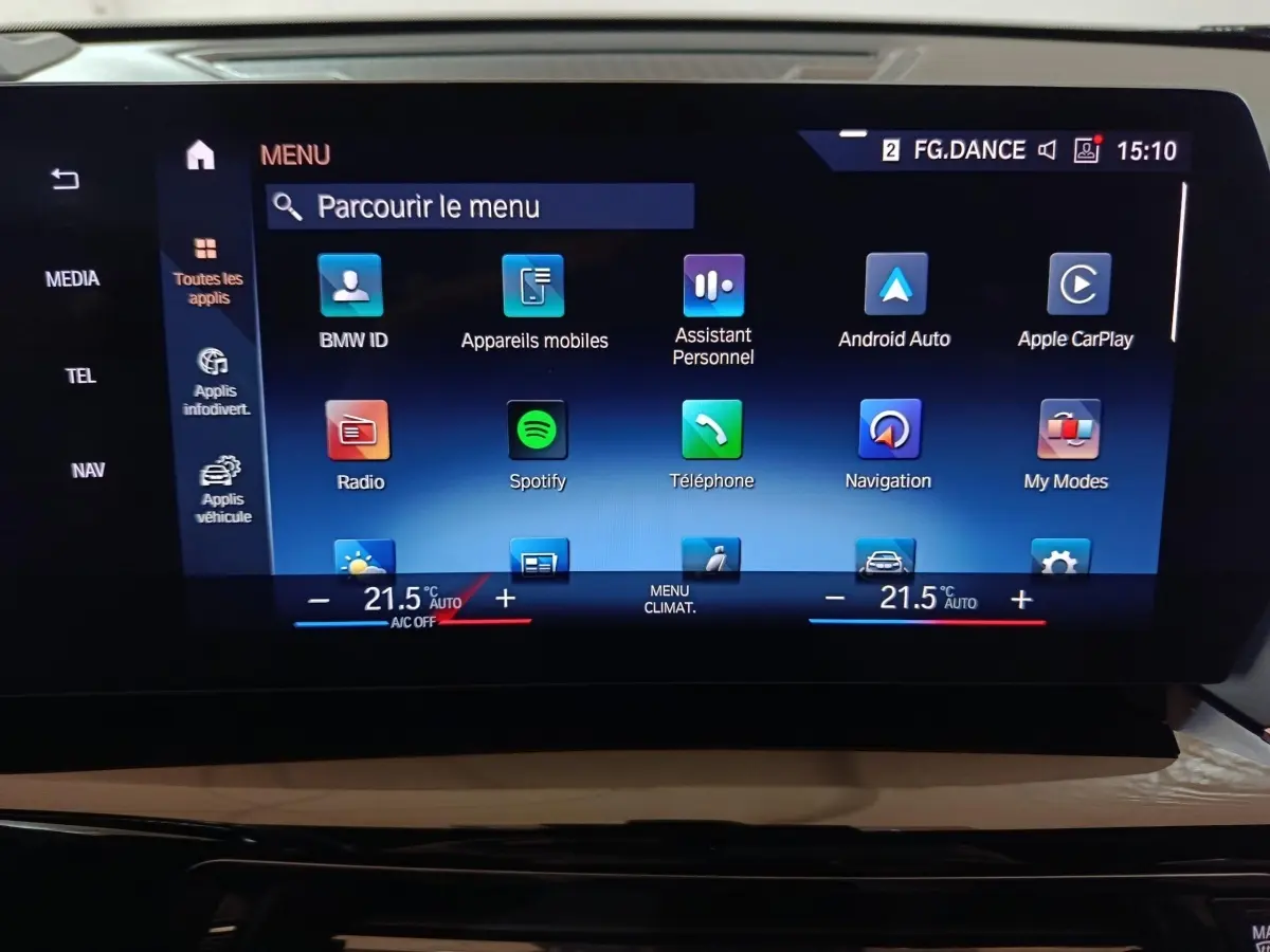 Écran tactile central du tableau de bord du BMW X1 noir, affichant le menu multimédia et climatisation à 21,5°C.
