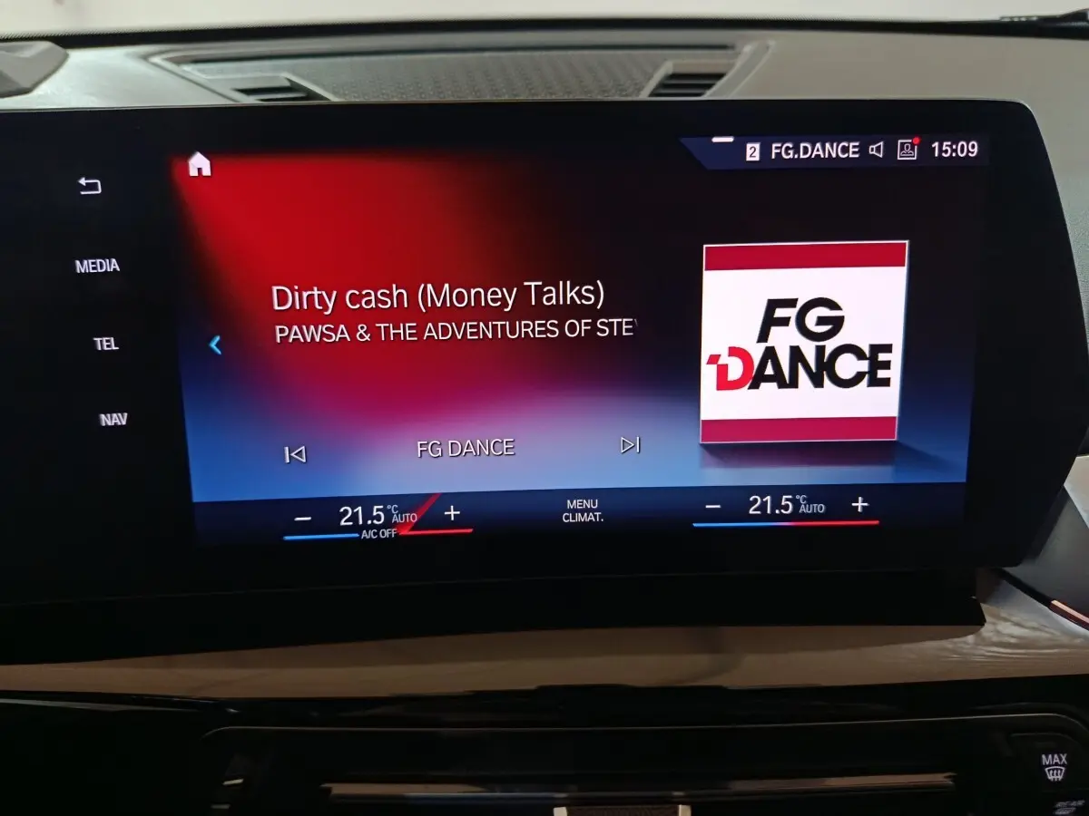 Écran tactile central du tableau de bord du BMW X1 noir, affichant la radio FG Dance et la climatisation à 21,5°C.