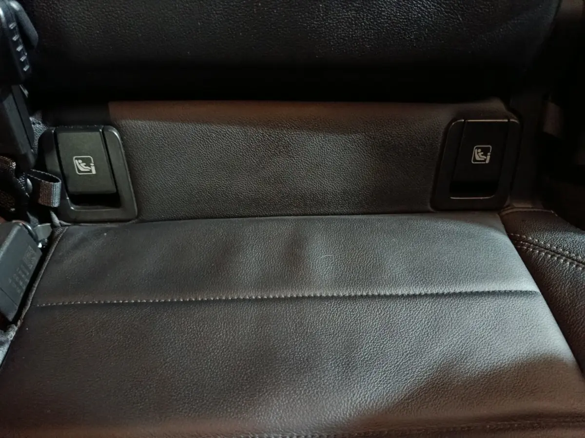 Gros plan sur la banquette arrière noire en cuir du BMW X1 xDrive23i M Sport, avec boutons de rabattement des sièges.