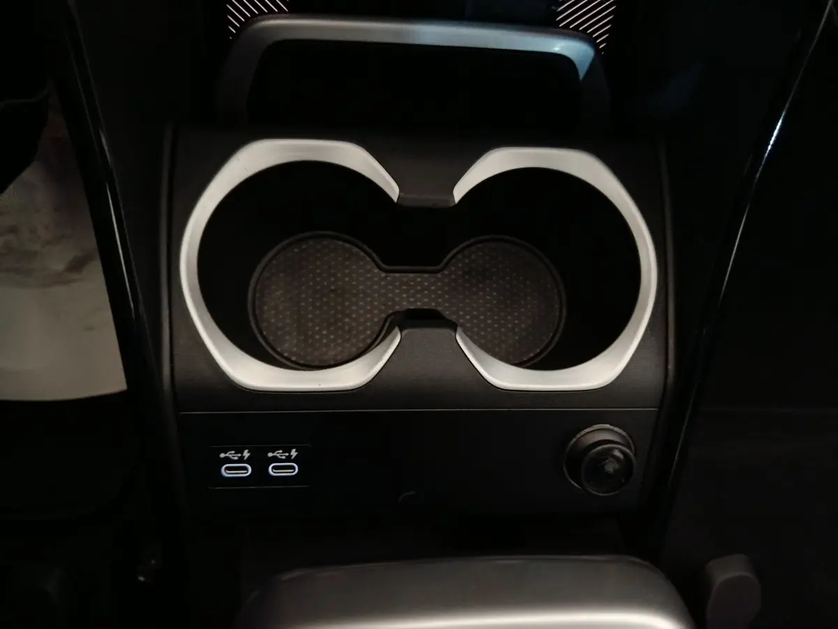 Gros plan sur la console centrale noire du BMW X1 xDrive23i M Sport 2023 avec porte-gobelets et ports USB-C.