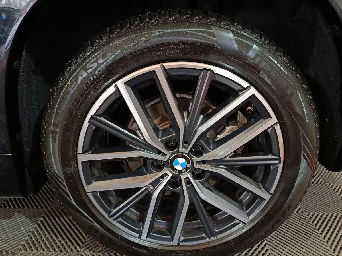 Gros plan sur la jante alliage noire et argentée d’un BMW X1 xDrive23i M Sport 2023 avec pneu Pirelli.