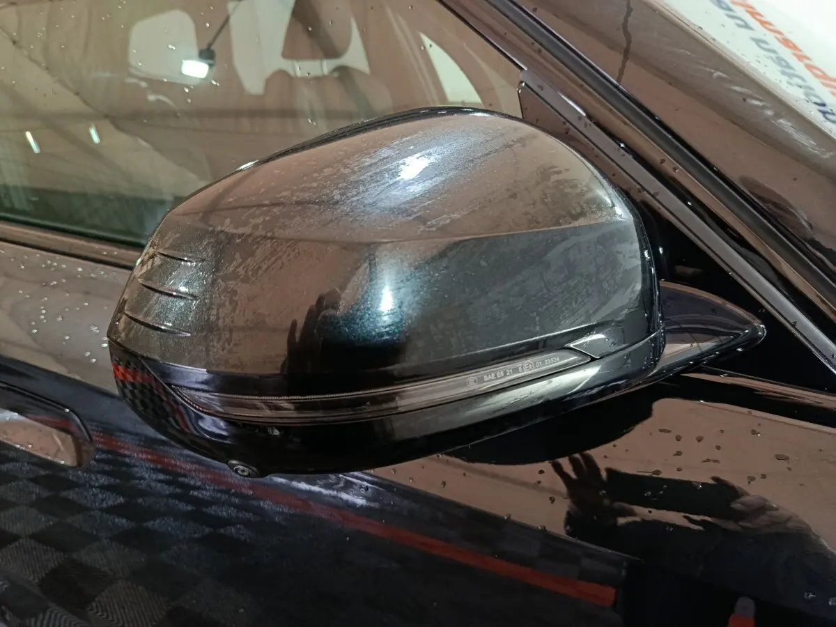 Rétroviseur côté gauche noir brillant de BMW X1 xDrive23i M Sport 2023 avec clignotant intégré, vue rapprochée.