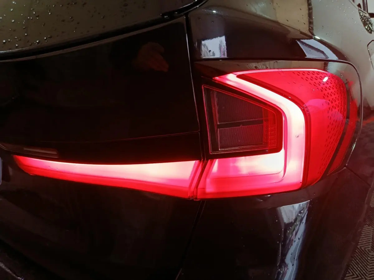 Gros plan sur le feu arrière droit allumé d’un BMW X1 noir xDrive23i M Sport 2023.