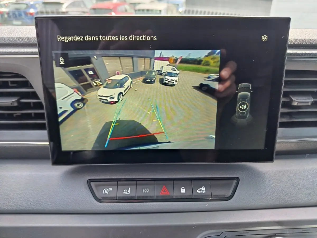 Écran tactile intérieur du Renault Master blanc montrant la caméra de recul avec vue arrière et aides au stationnement.