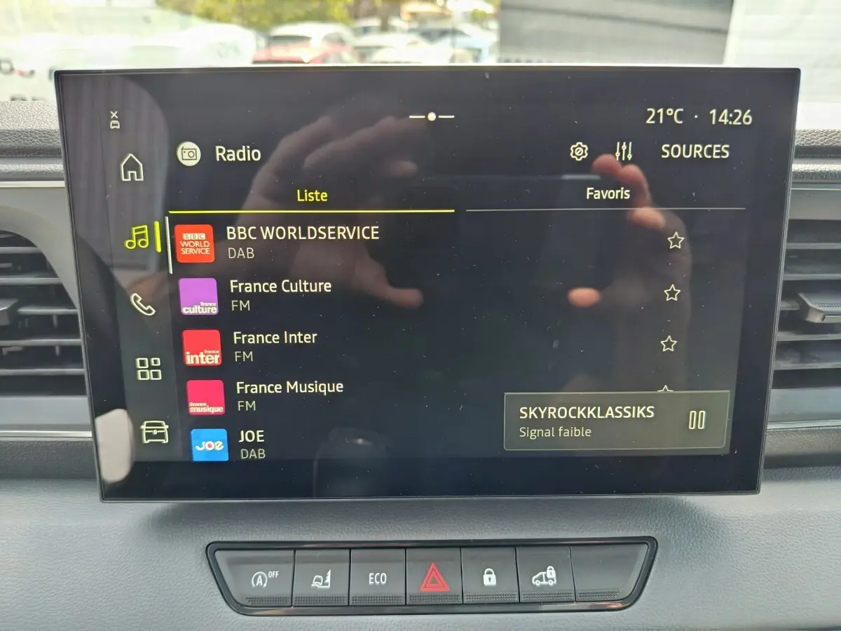 Écran tactile central du tableau de bord du Renault Master 2025 affichant les stations radio avec commandes en dessous.