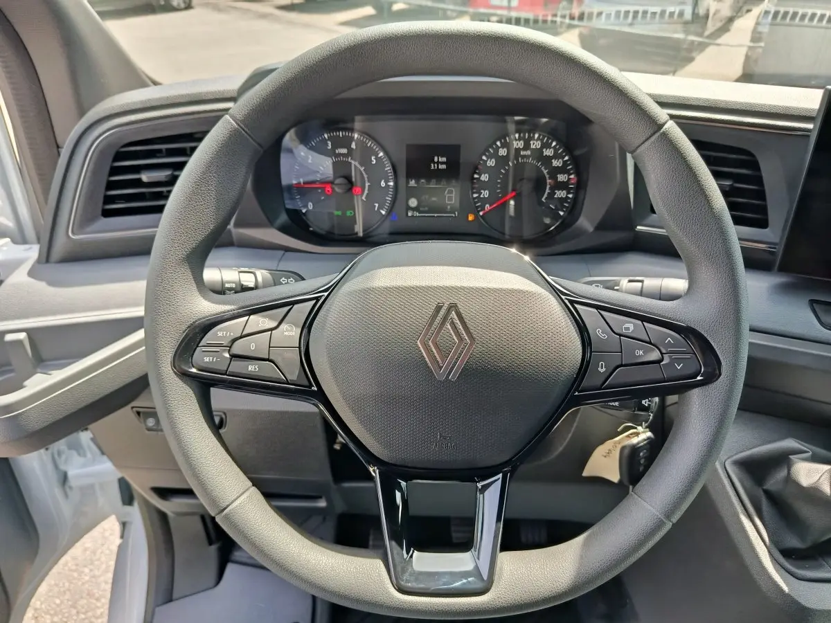 Vue rapprochée du volant noir du Renault Master 2025 avec tableau de bord et commandes visibles.