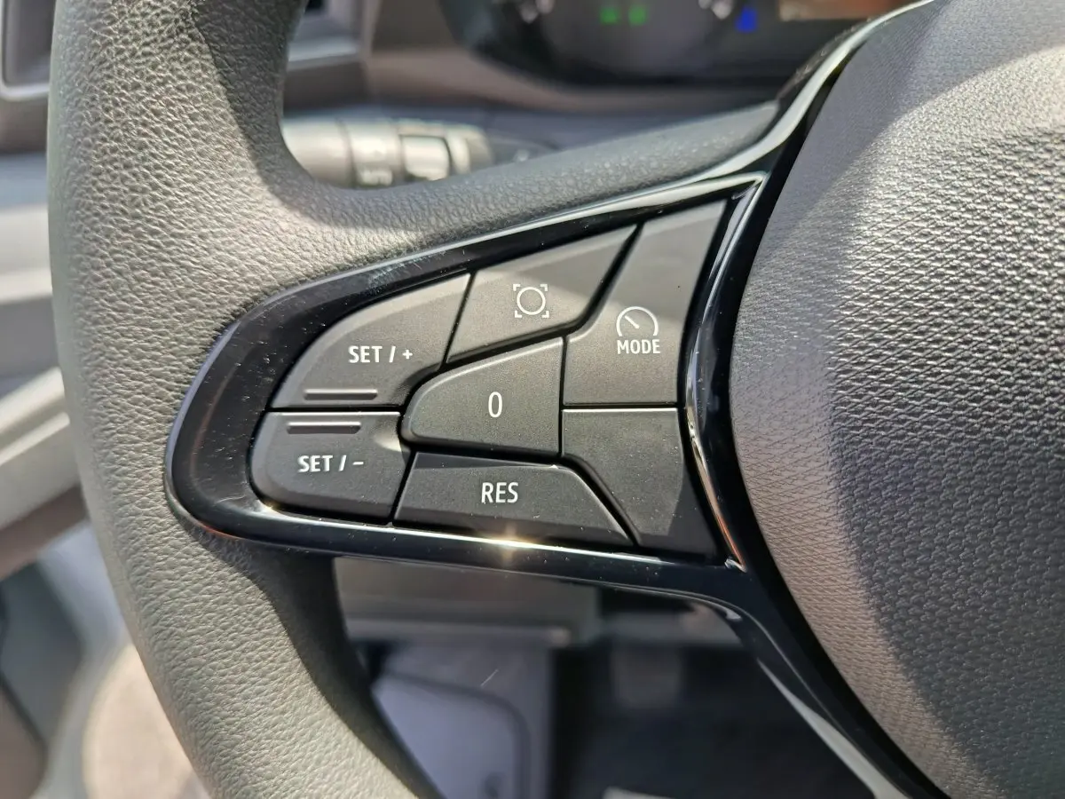 Gros plan sur les commandes de régulateur de vitesse au volant noir du Renault Master 2025, version FG L2H2 blanche.