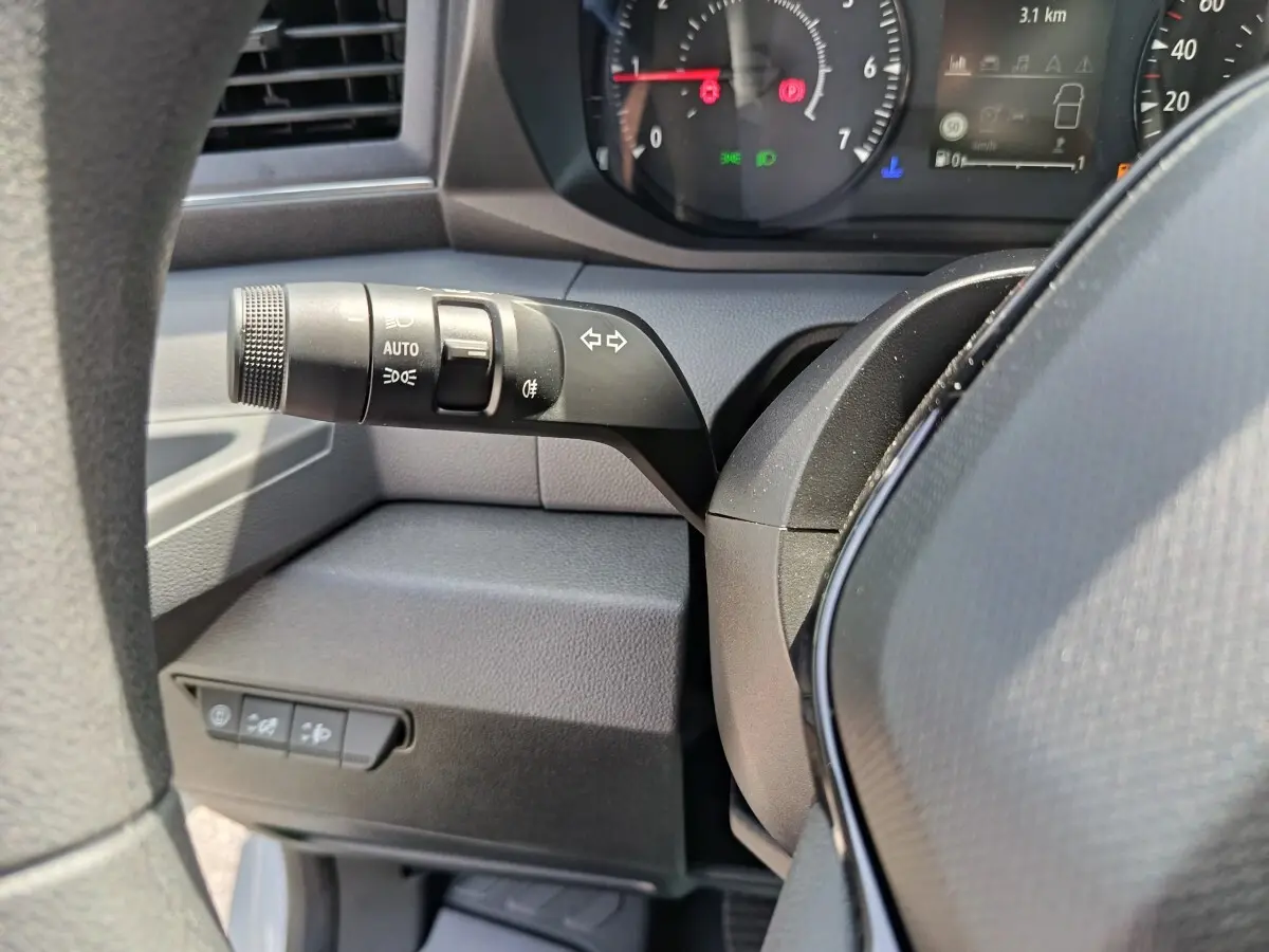 Gros plan sur la manette de clignotants et commandes d’éclairage à gauche du volant du Renault Master 2025, intérieur noir.