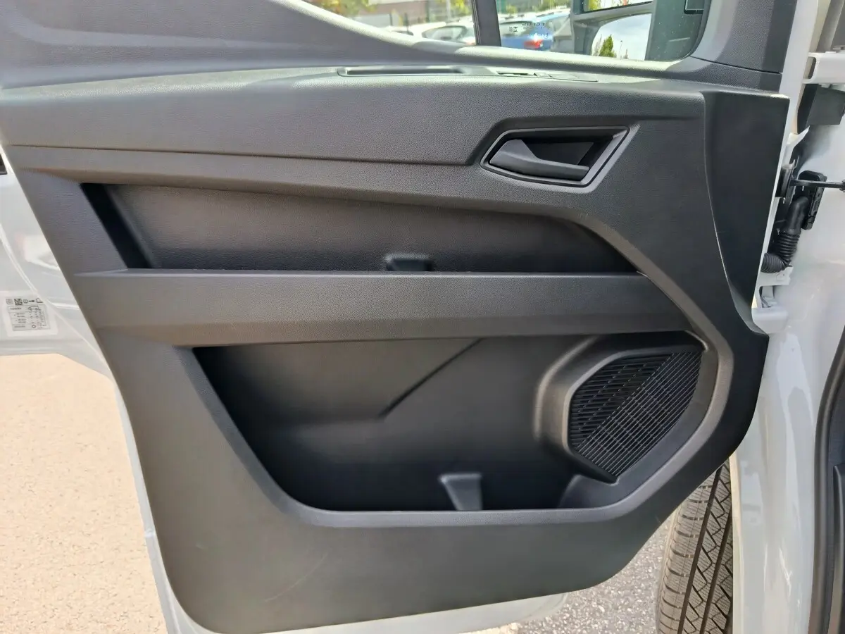 Vue rapprochée de la porte avant droite noire intérieure du Renault Master blanc, avec haut-parleur intégré.