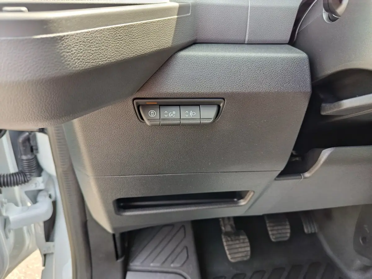 Détail intérieur côté gauche du tableau de bord du Renault Master blanc, avec commandes d’éclairage et pédales visibles.