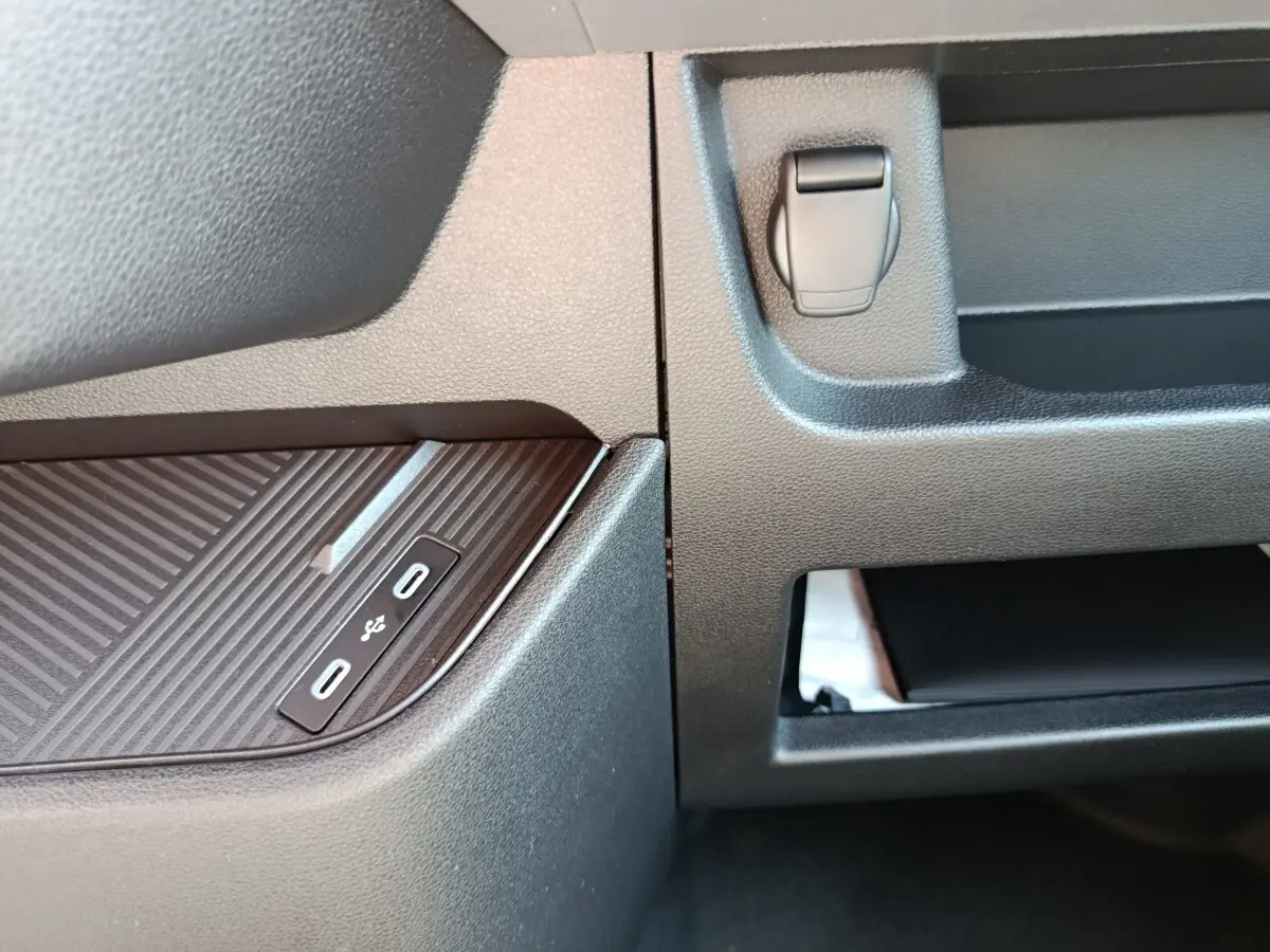 Gros plan sur la console centrale du Renault Master blanc 2025, montrant les ports USB-C doubles et un rangement ouvert.