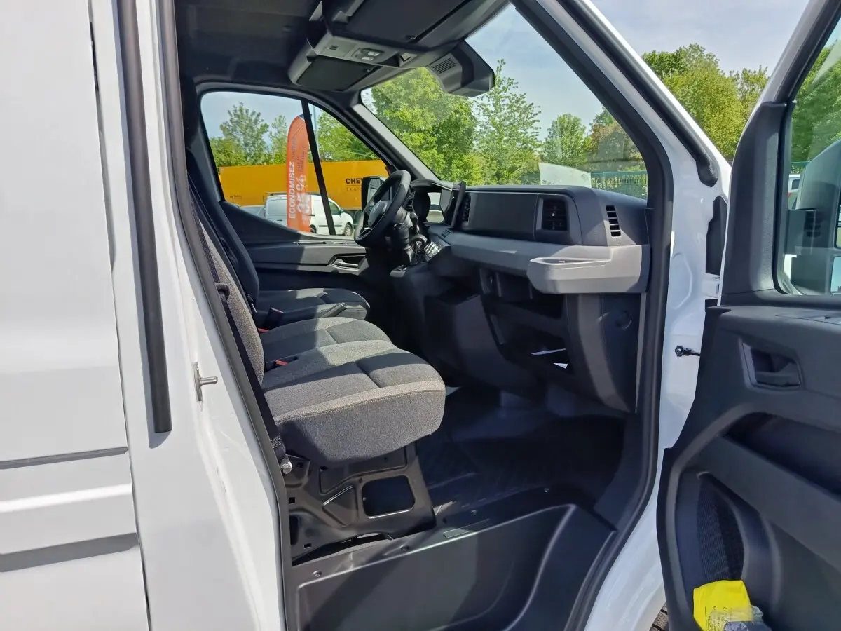 Vue intérieure côté conducteur du Renault Master blanc 2025, montrant les sièges et le tableau de bord moderne.