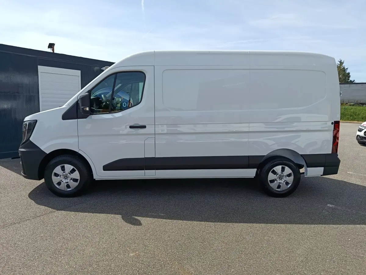 Vue de profil côté gauche d’un utilitaire Renault Master blanc avec bande noire sur les portières et jantes argentées.