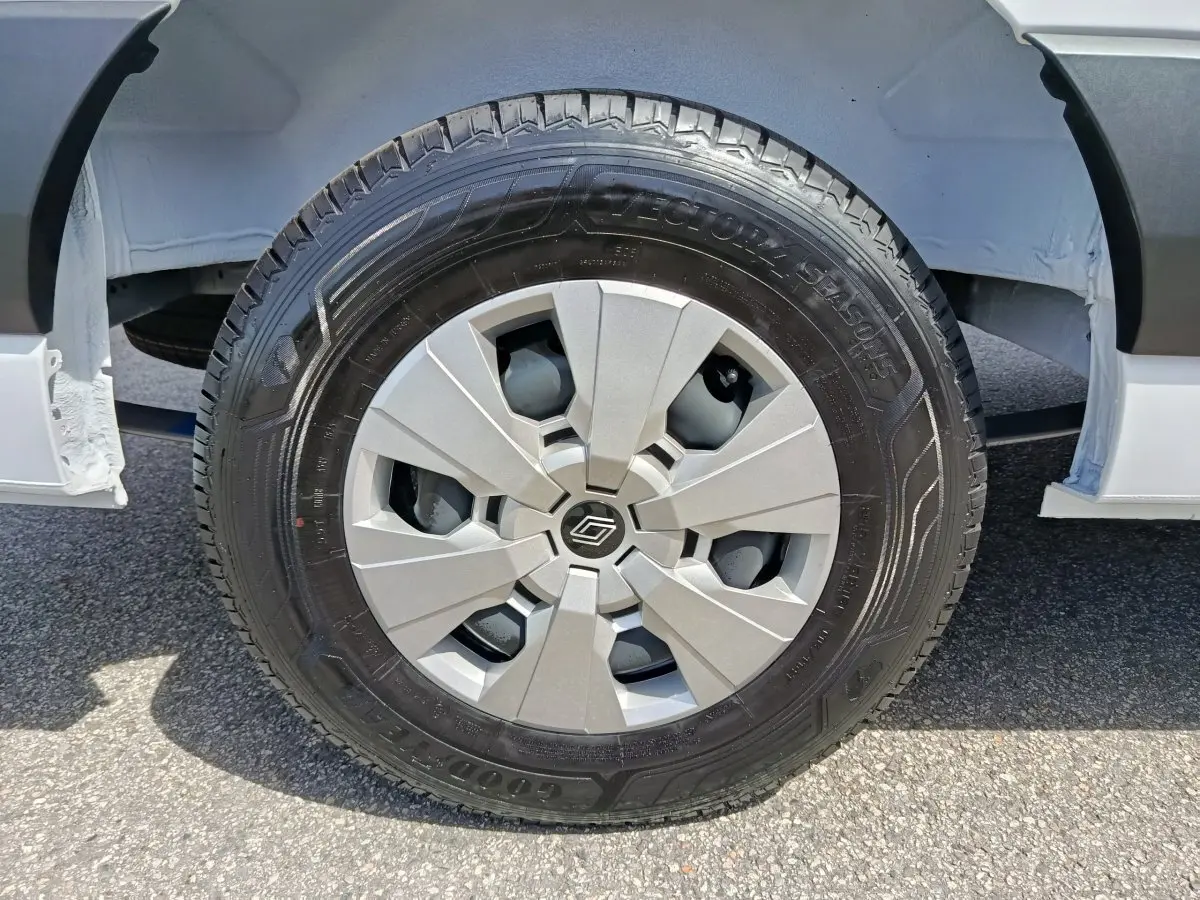 Gros plan sur la roue avant gauche blanche du Renault Master FG L2H2 avec jante argentée et pneu Goodyear.