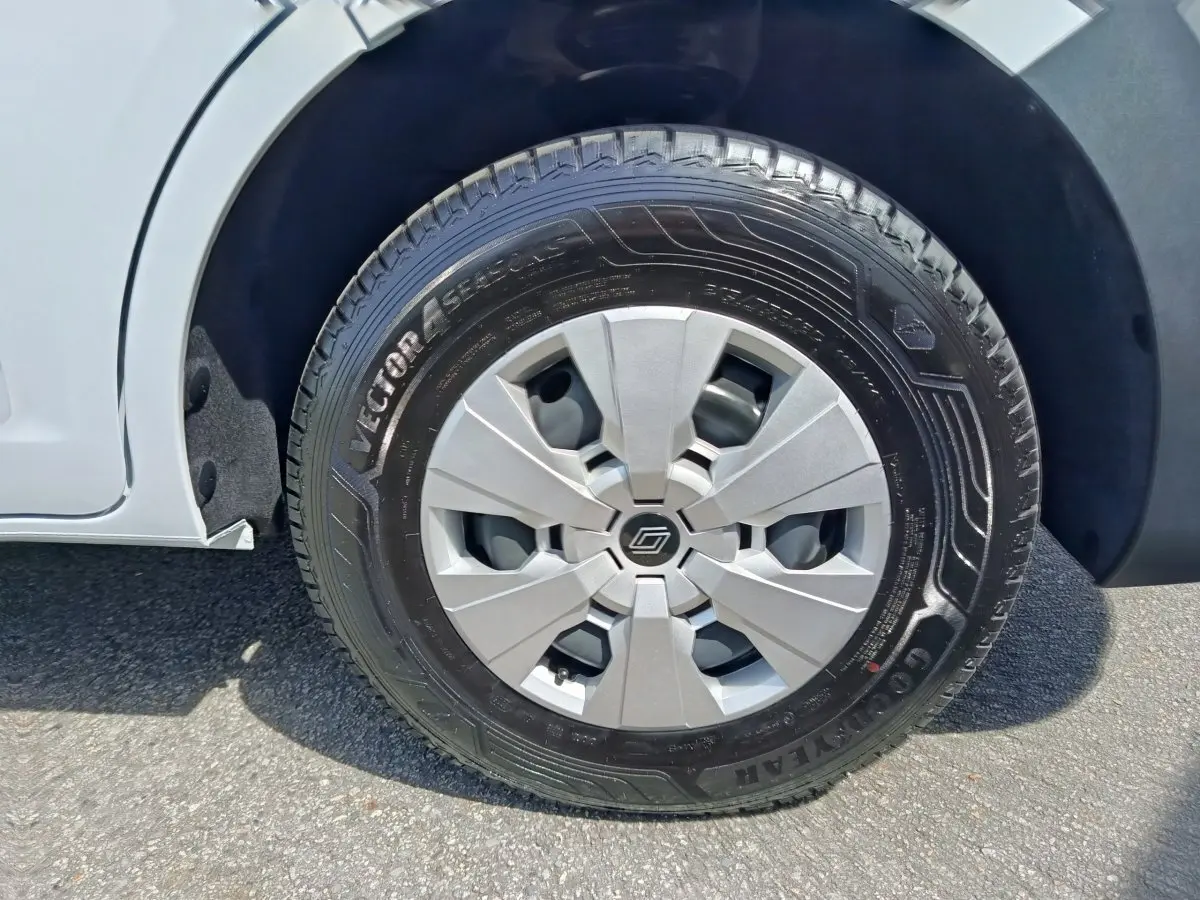 Gros plan sur la roue avant gauche du Renault Master blanc, avec jante argentée et pneu Goodyear Vector 4Seasons.