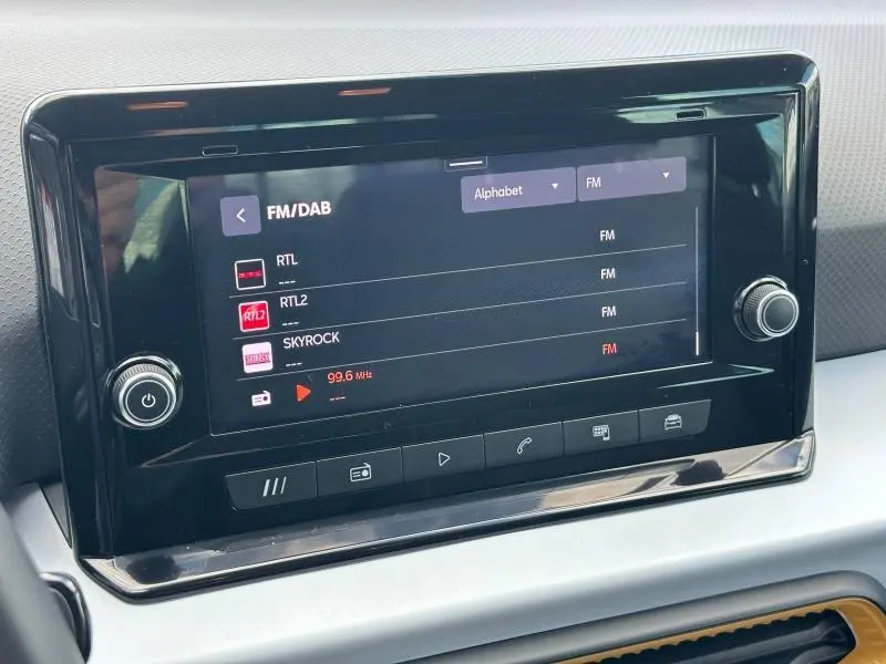 Écran tactile central du tableau de bord du SEAT Arona 2025 affichant les stations FM/DAB.