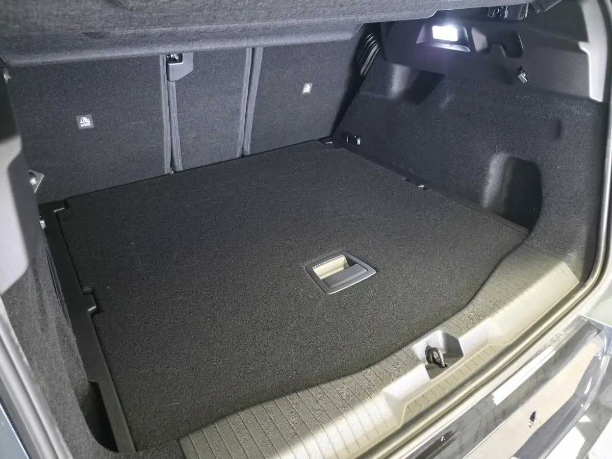 Vue intérieure du coffre du Citroën C5 Aircross vert, montrant le plancher plat et l'éclairage intégré.