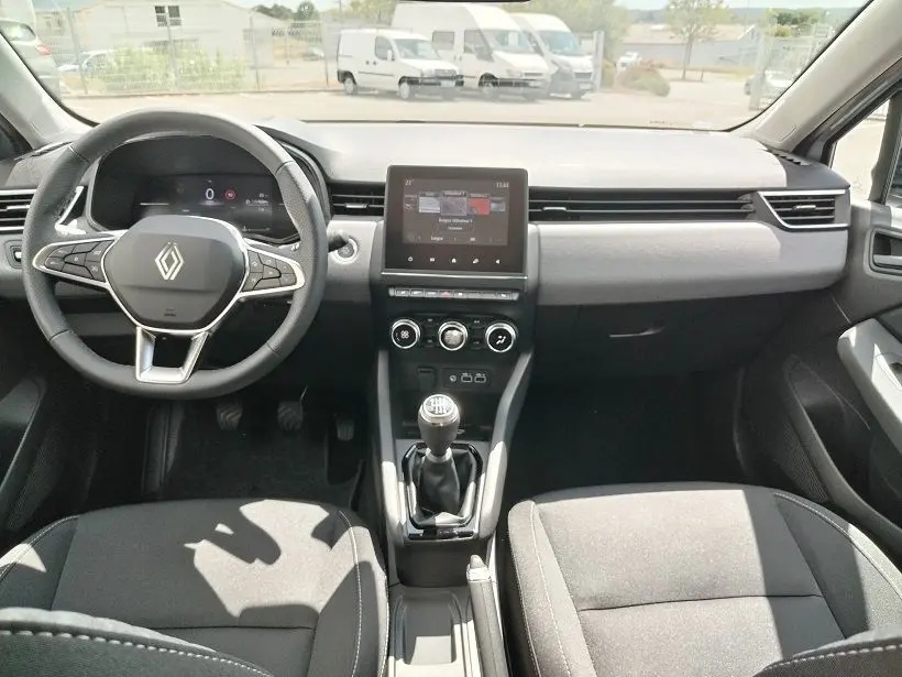 Vue intérieure avant de la Renault Clio V TCE 90 Evolution 2026, tableau de bord noir avec écran tactile et boîte manuelle.