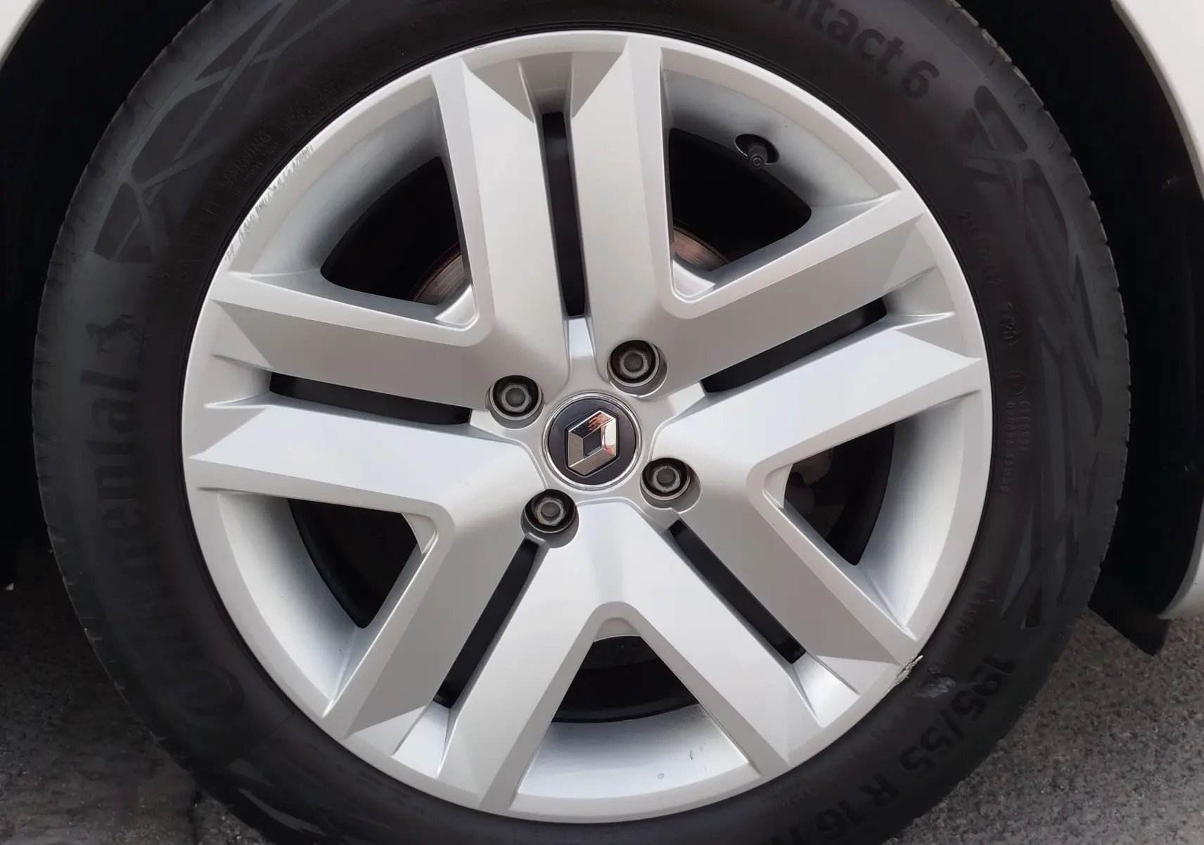 Gros plan sur la jante en alliage argentée d'une Renault Clio V Business gris platine, avec logo Renault au centre.