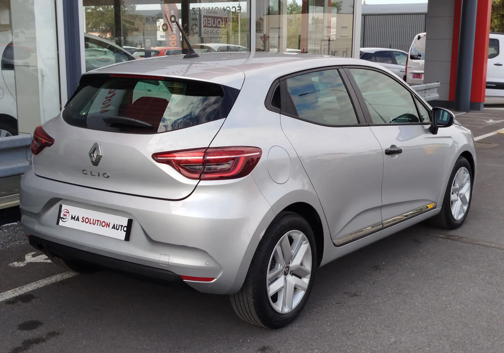 Renault Clio V Business gris platine vue 3/4 arrière droit, avec feux LED et jantes alliage visibles.