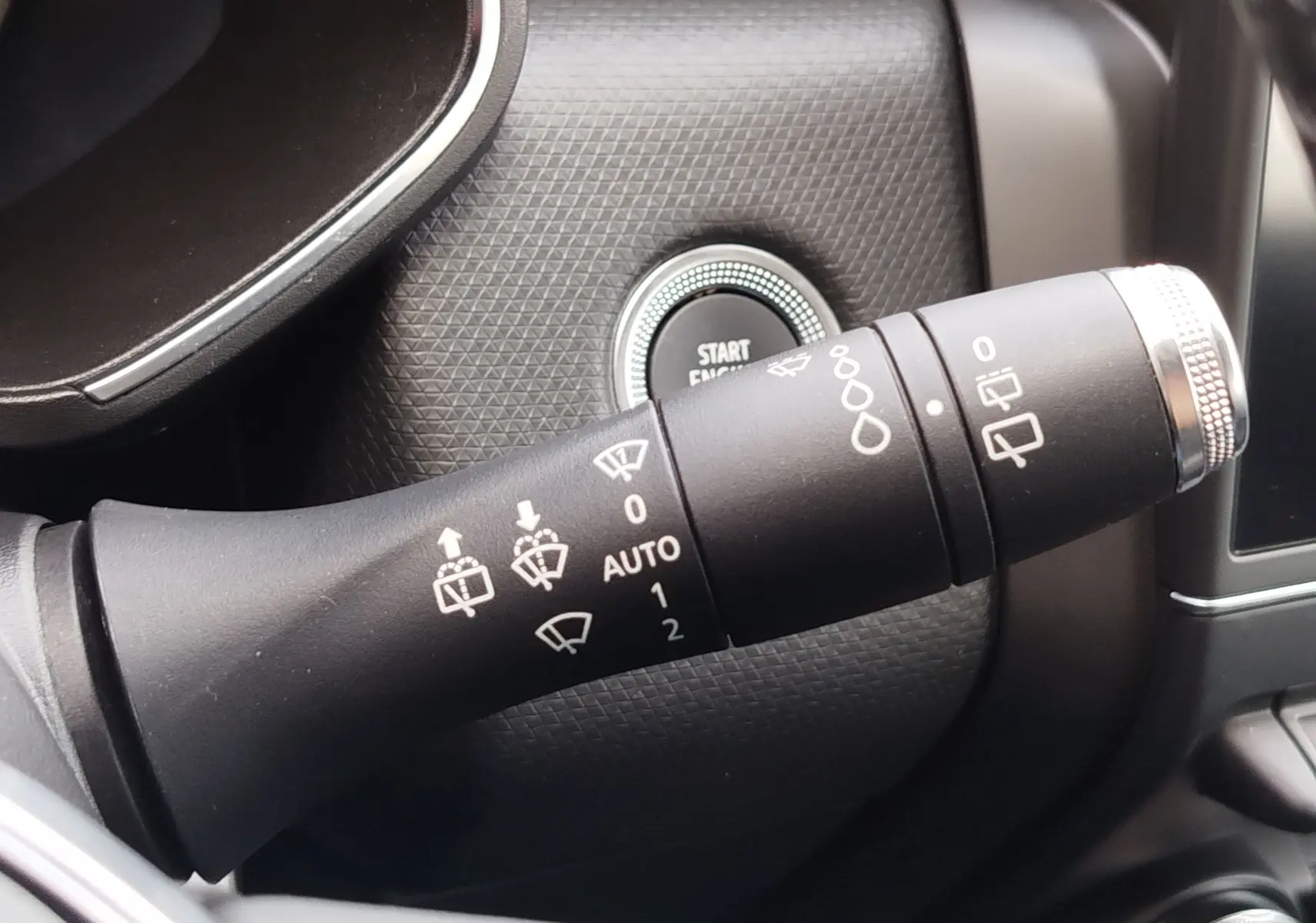 Gros plan sur la manette de commande des essuie-glaces dans l'habitacle gris d'une Renault Clio V Business 2020.