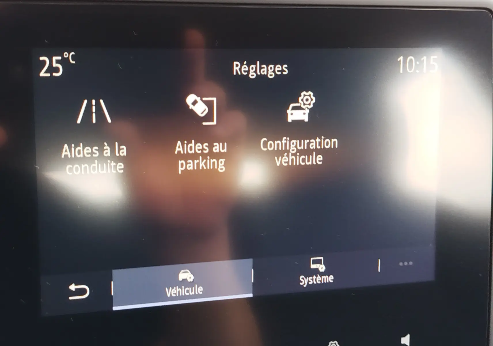 Écran tactile intérieur de la Renault Clio V Business montrant les réglages d’aides à la conduite, parking et configuration véhicule.