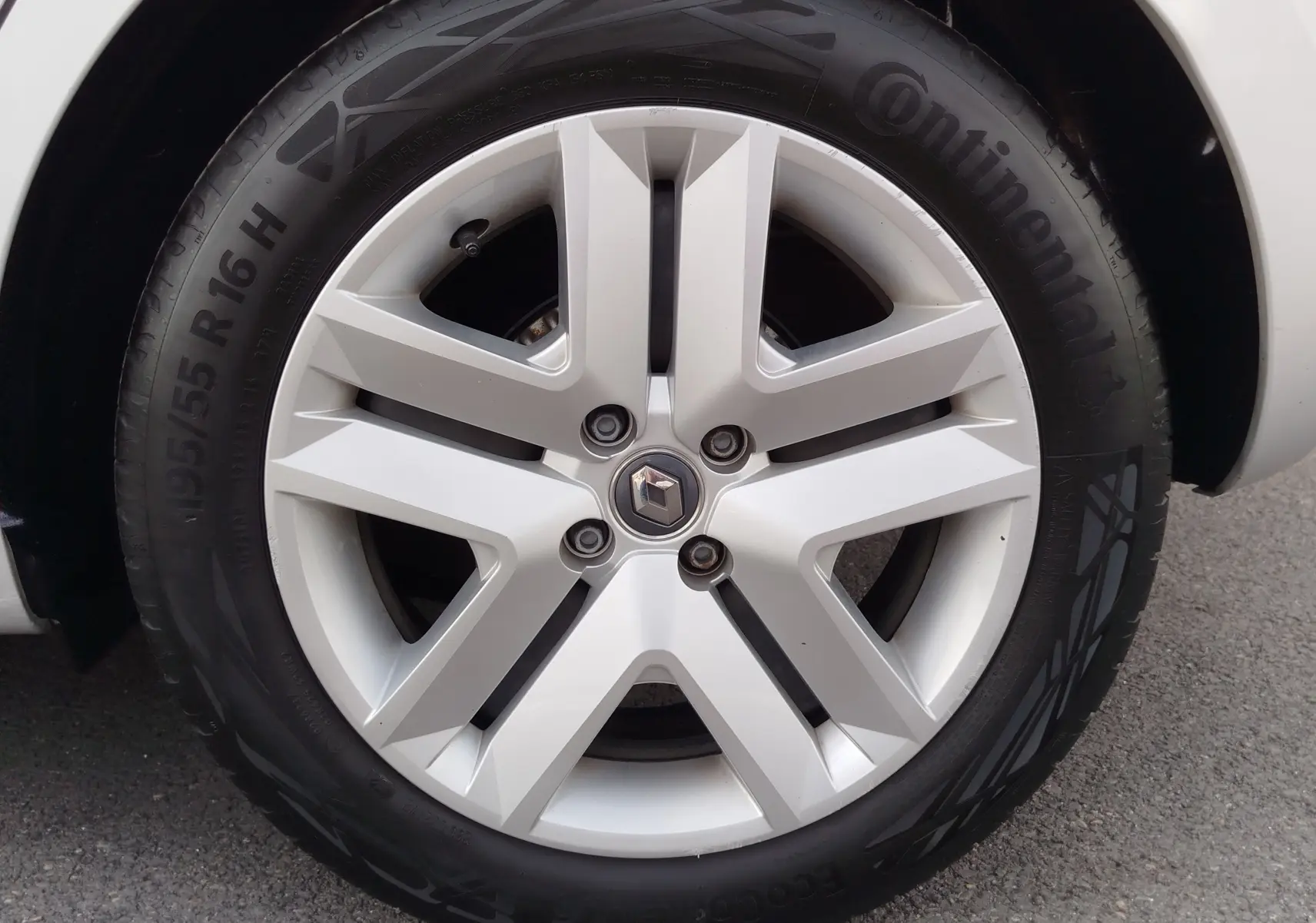 Gros plan sur la roue avant droite d'une Renault Clio V gris platine avec jante alliage à cinq branches.