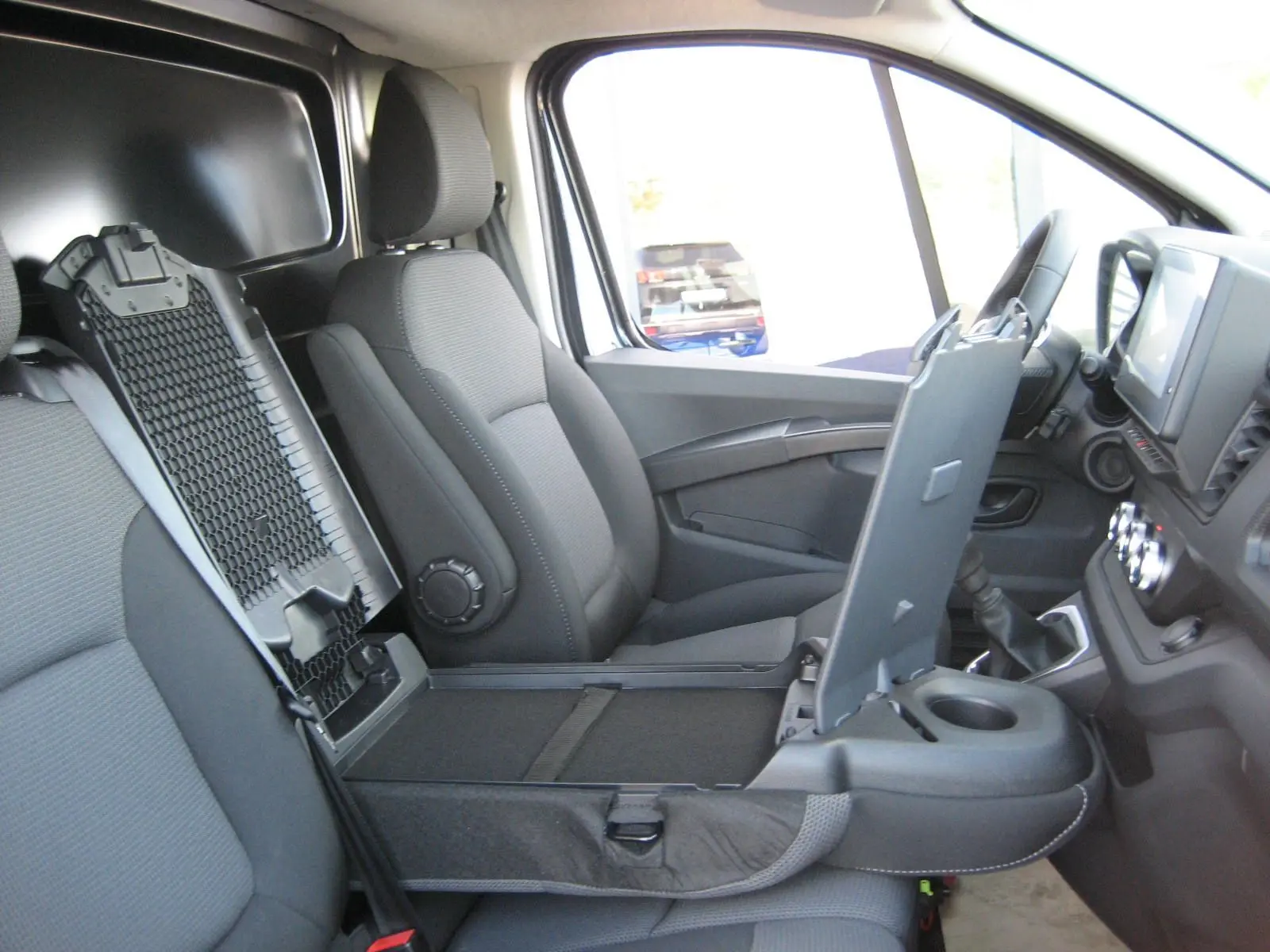 Intérieur du Renault Trafic Fourgon L1H1 Advance 2025, vue côté droit sur sièges gris et console centrale relevée.