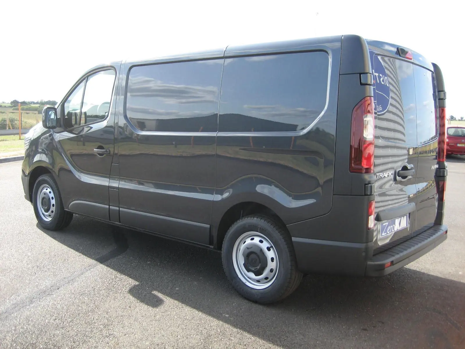 Vue 3/4 arrière droite du Renault Trafic Fourgon gris comète, soulignant ses lignes épurées et ses feux arrière verticaux.