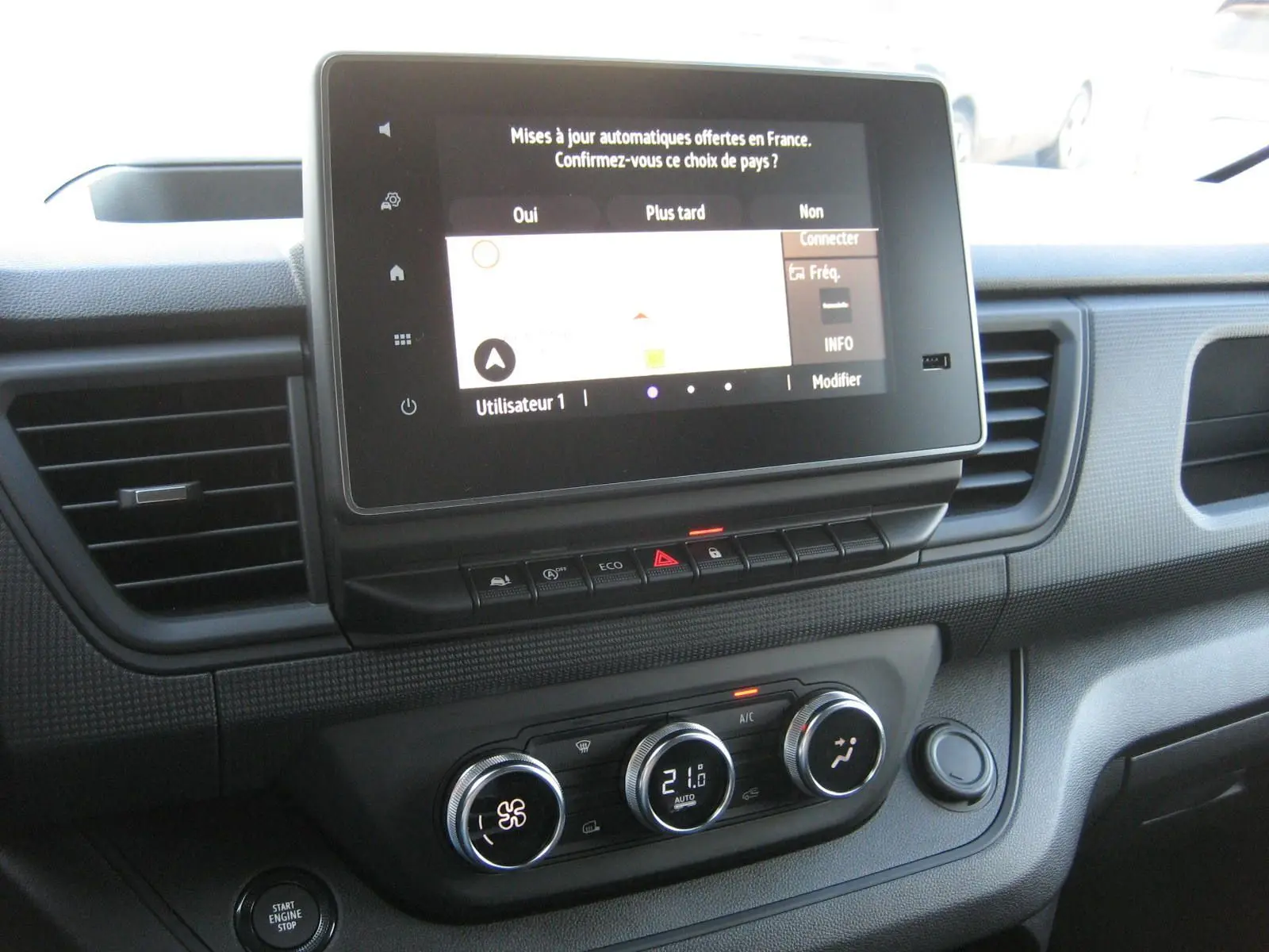 Tableau de bord du Renault Trafic Fourgon gris Comète 2025 avec écran tactile et commandes climatisation visibles.