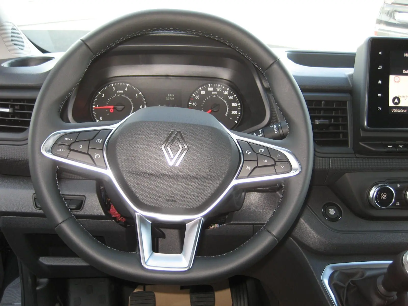 Vue rapprochée du volant noir du Renault Trafic Fourgon L1H1 Advance 2025 avec commandes intégrées et tableau de bord visible.