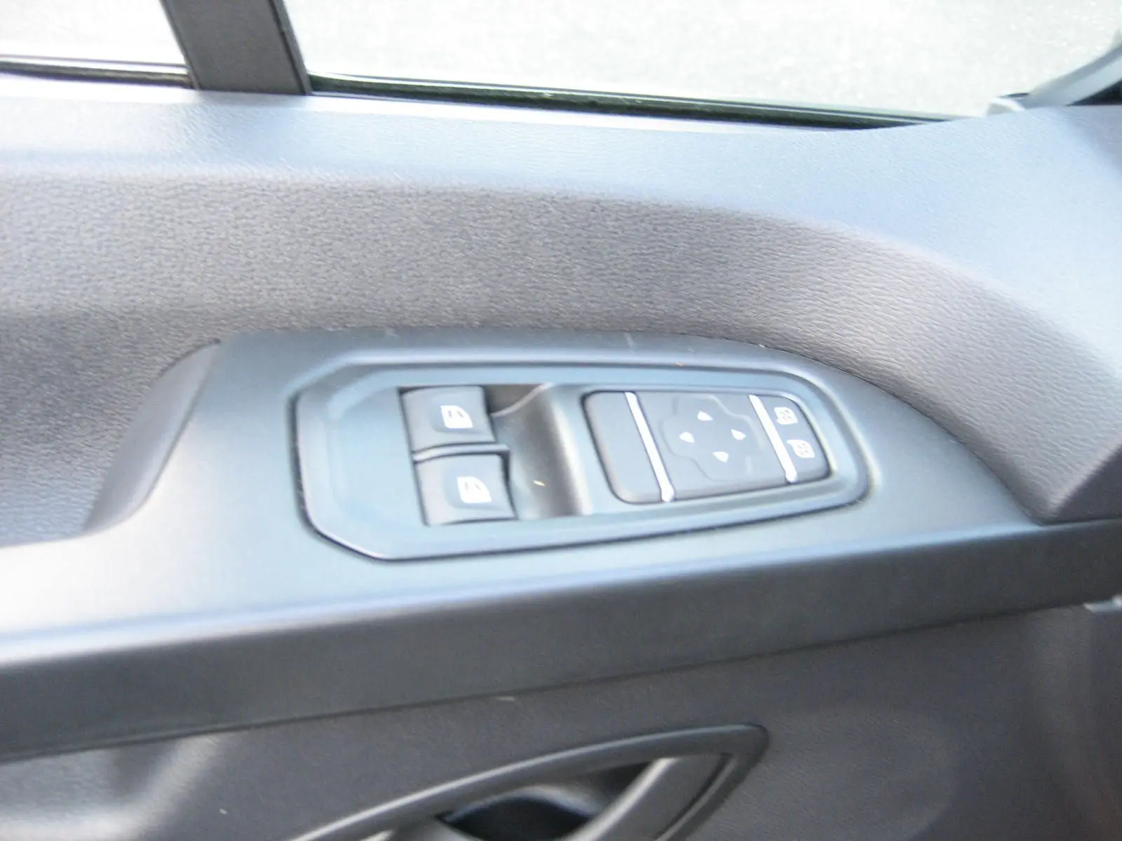 Panneau de commandes des vitres électriques côté conducteur du Renault Trafic Fourgon gris Comète 2025.