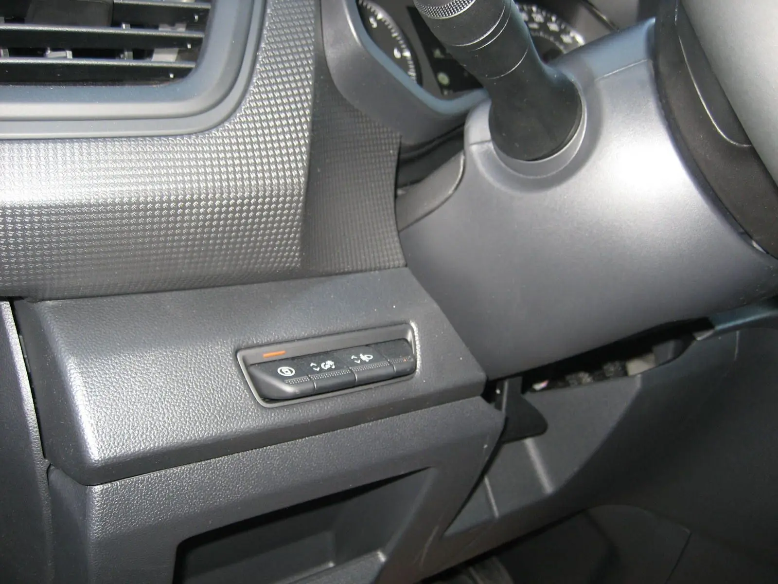 Vue rapprochée des commandes situées à gauche du volant dans l'habitacle du Renault Trafic Fourgon gris comète 2025.