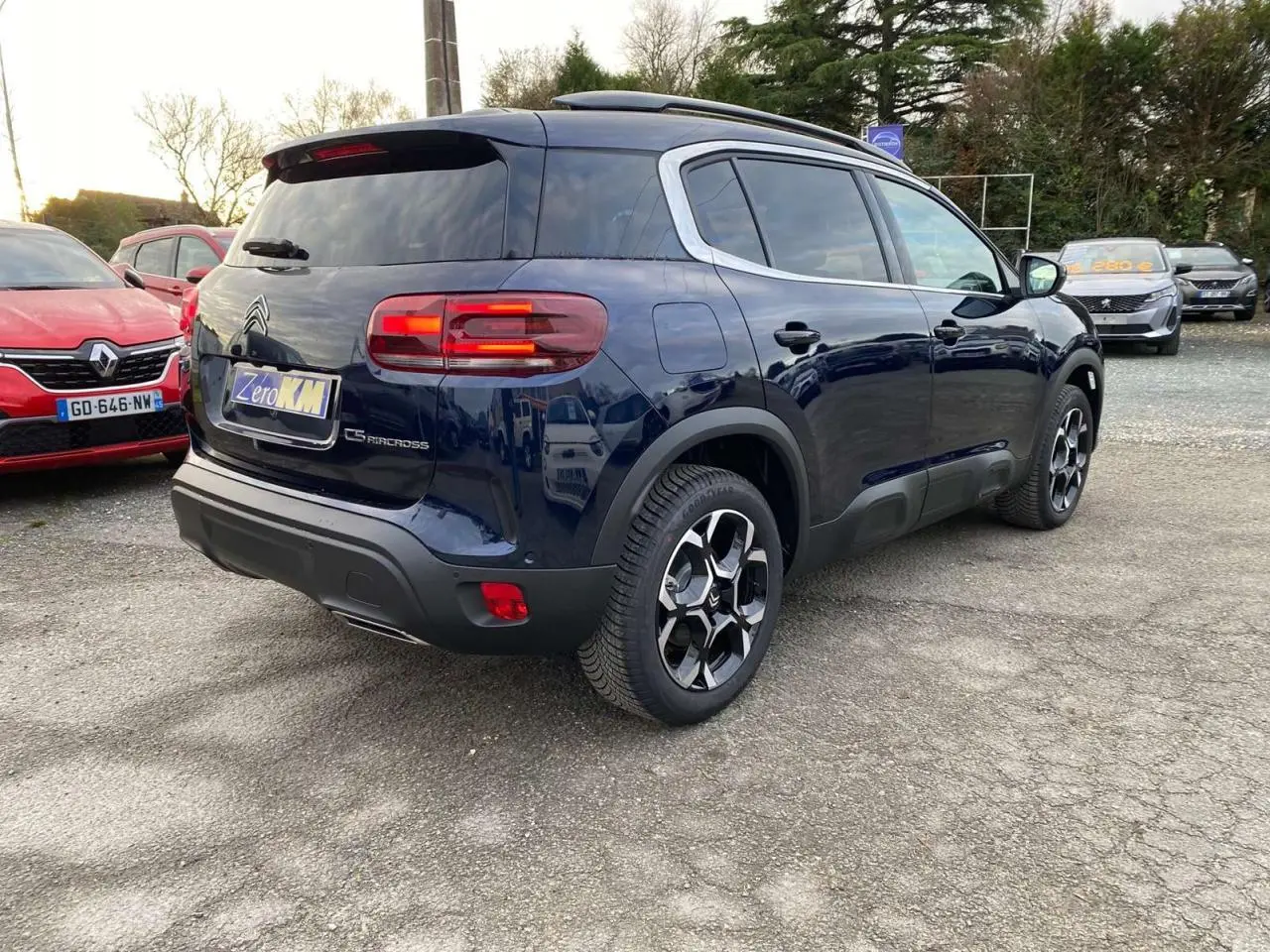Vue 3/4 arrière droite d'un Citroën C5 Aircross bleu éclipse avec vitres surteintées et jantes alliage distinctives.