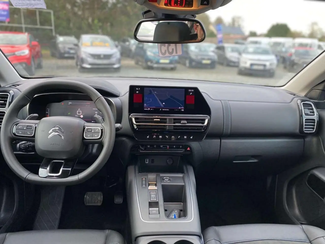 Intérieur du Citroën C5 Aircross 2025 vu de face, tableau de bord noir avec écran tactile de navigation allumé.