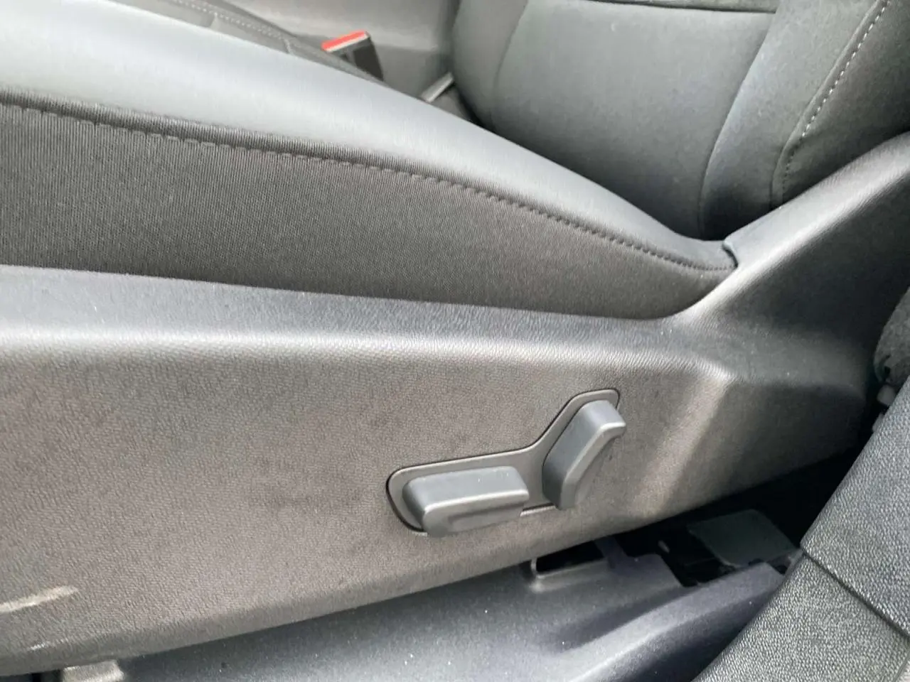 Gros plan sur les commandes électriques du siège avant en tissu gris foncé du Citroën C5 Aircross 2025.