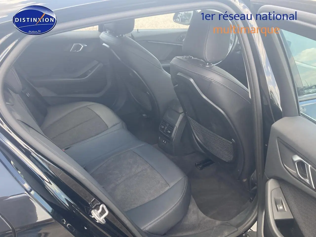 Vue intérieure arrière côté droit de la BMW Série 1 noire 118i 2023, sièges sport en tissu et similicuir anthracite.