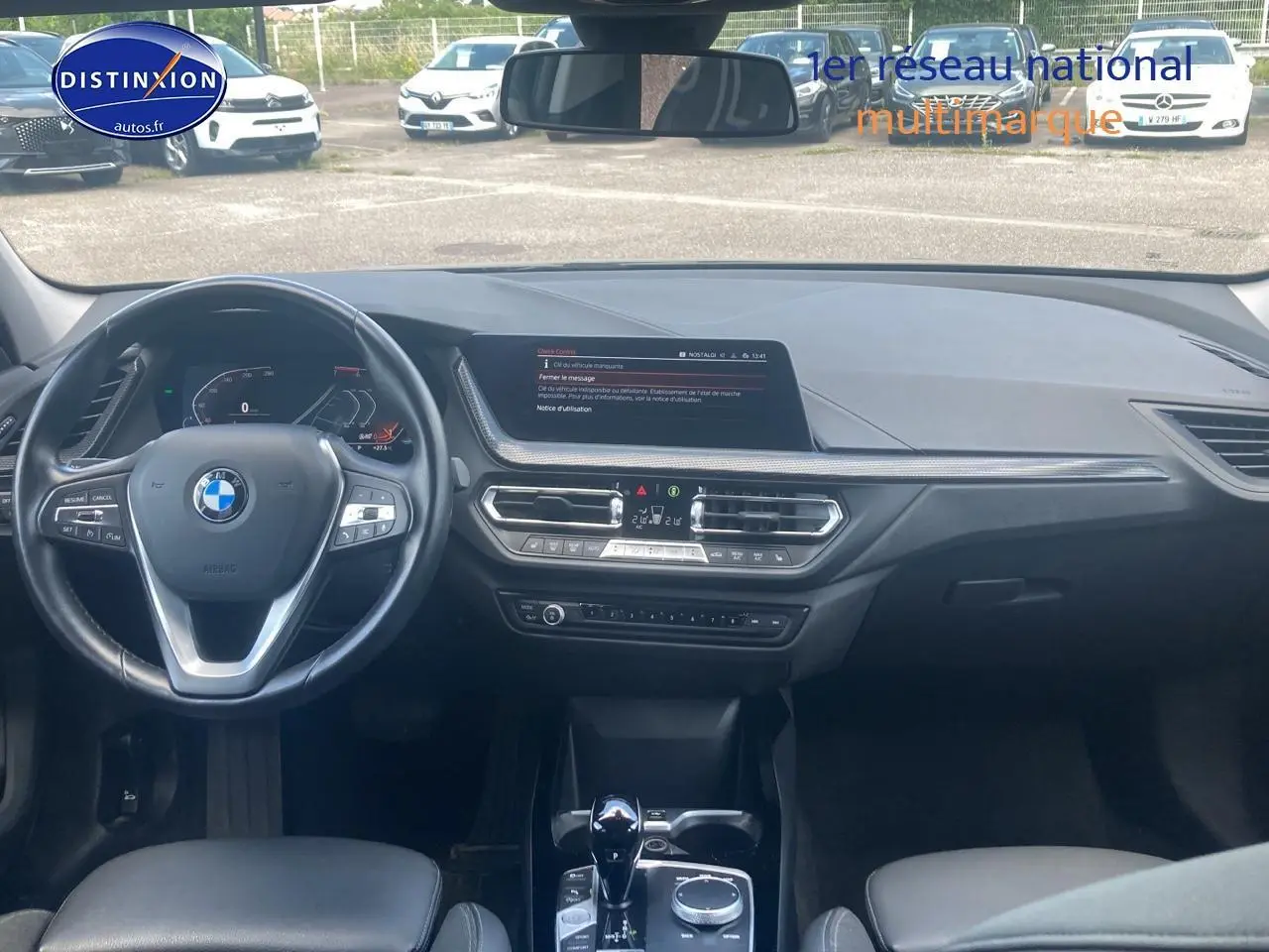 Vue intérieure frontale du tableau de bord noir de la BMW Série 1 (f40) 118i avec volant multifonction et écran central.