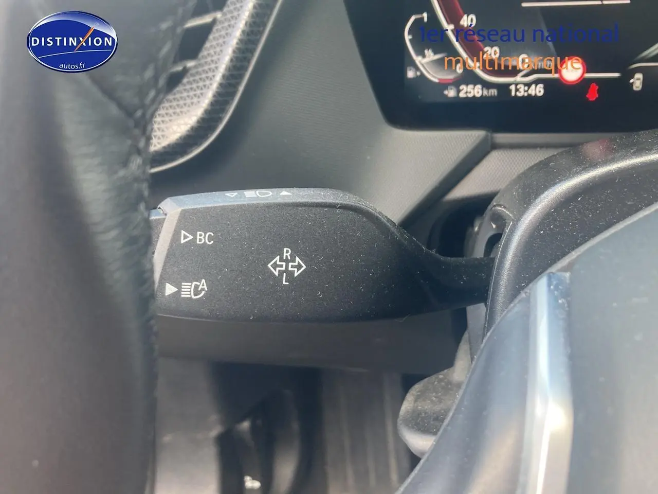 Gros plan sur la commande de clignotant à gauche du volant dans l’habitacle d’une BMW Série 1 noire 2023.