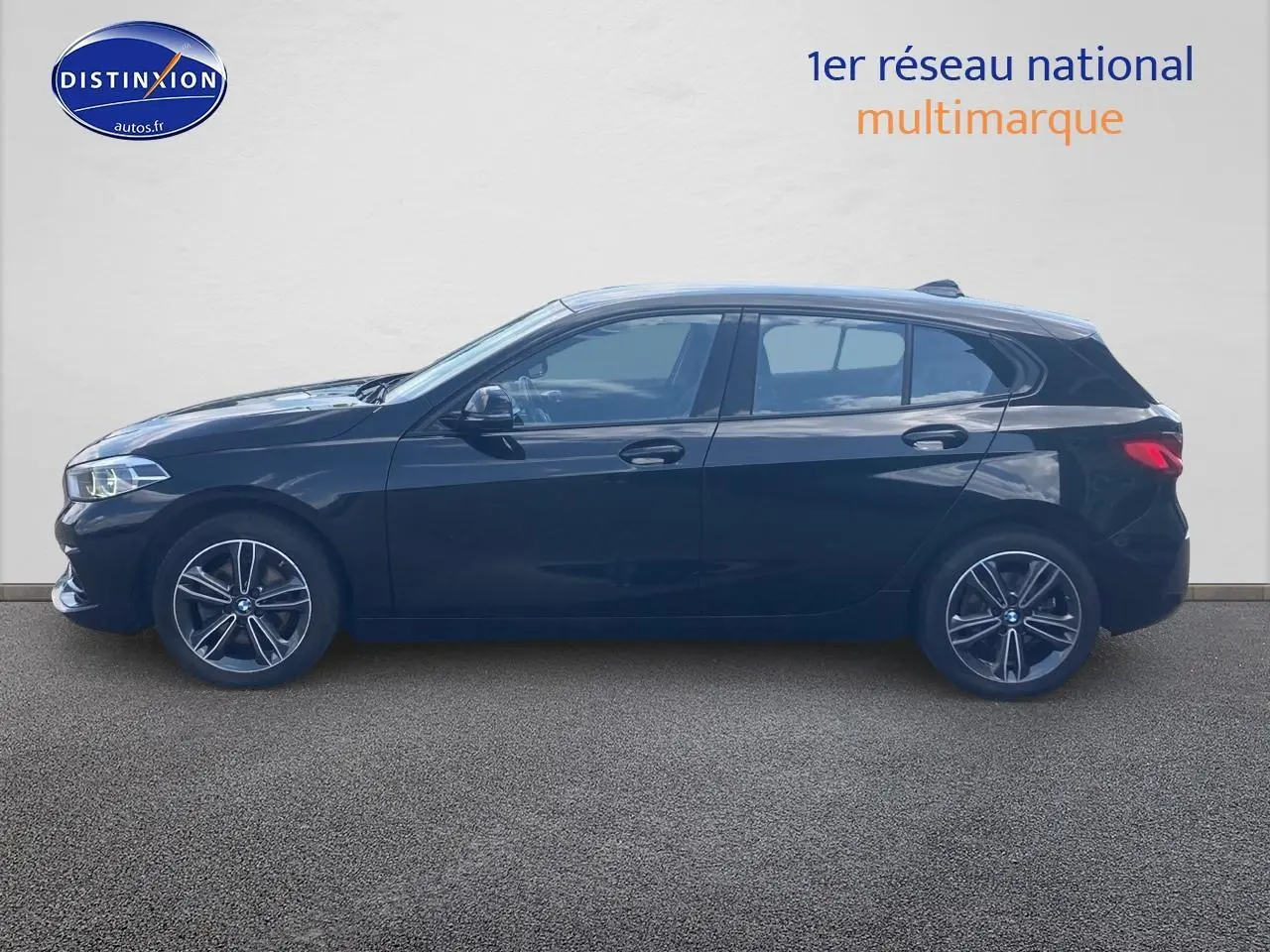 BMW Série 1 noire vue de profil côté gauche, avec jantes alliage 17 pouces et lignes épurées sportives.