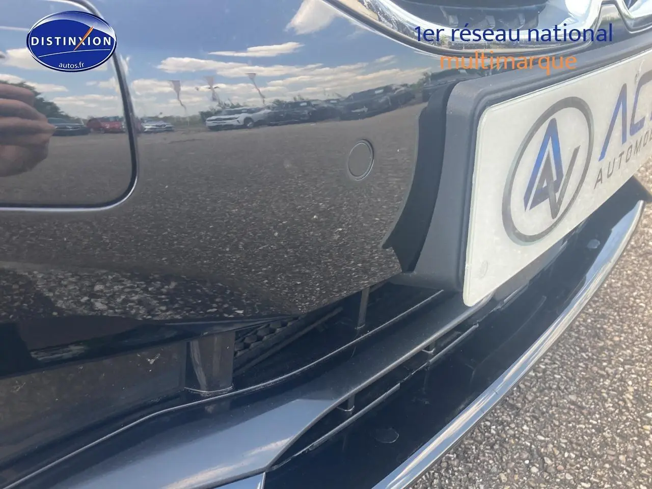 Gros plan sur le pare-chocs avant noir brillant de la BMW Série 1 (f40) 118i avec capteur de stationnement visible.