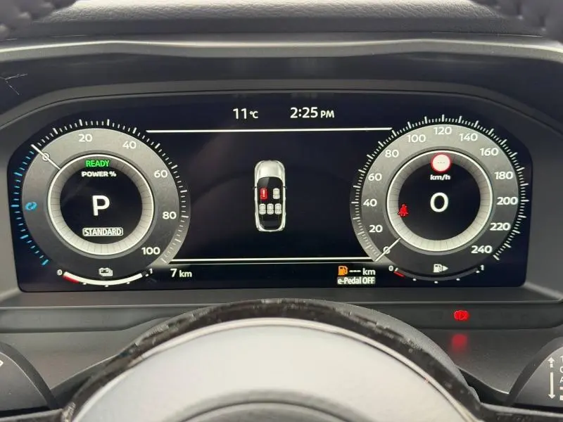 Vue rapprochée du tableau de bord numérique du Nissan Qashqai Hybrid e-POWER 2025 avec affichage des compteurs et alertes.